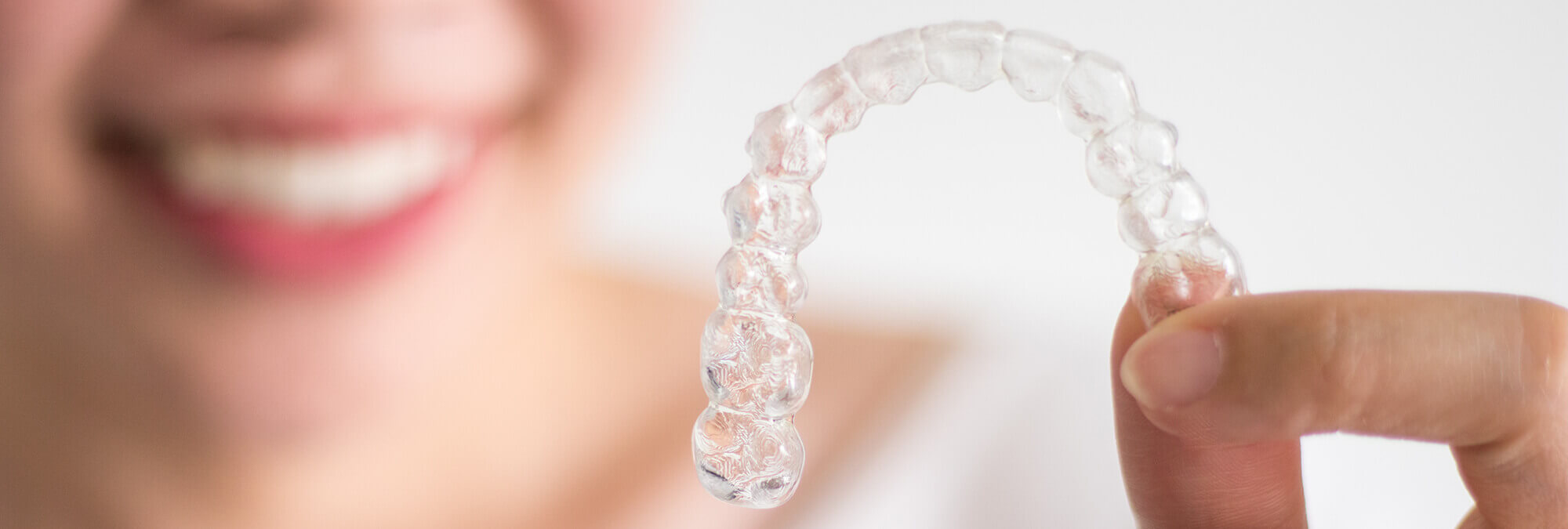 closeup of a person holding up their clear aligners