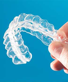 closeup of a person holding up their clear aligners