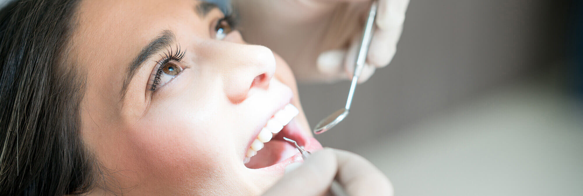 woman having her teeth examined by a dentist