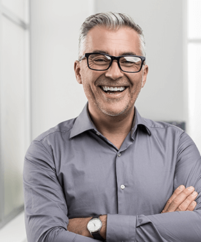 man smiling with his arms folded