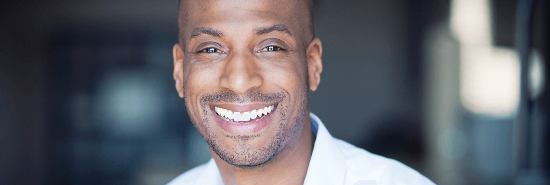 Black man smiling after dental implants.