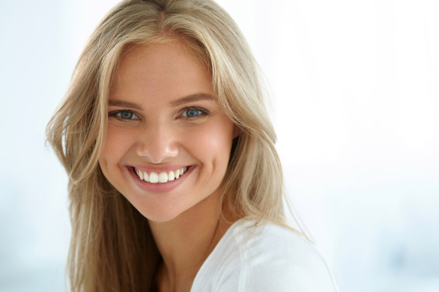 young blond woman flashes her white teeth in a smile
