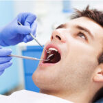 young man undergoing an oral cancer screening at the dentist