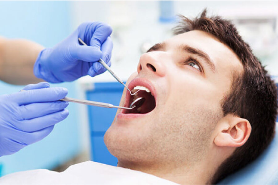young man undergoing an oral cancer screening at the dentist