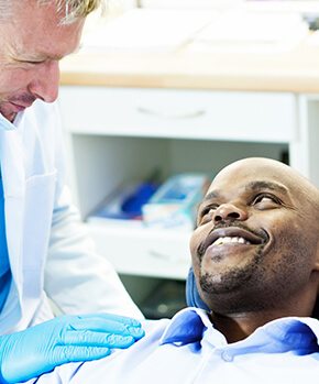 man being comforted by his dentist