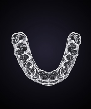 invisalign aligner against a dark background