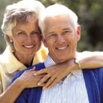 senior couple smile after learning about dental implants