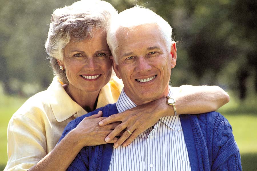 senior couple smile after learning about dental implants