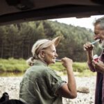 senior couple brush their teeth together while camping